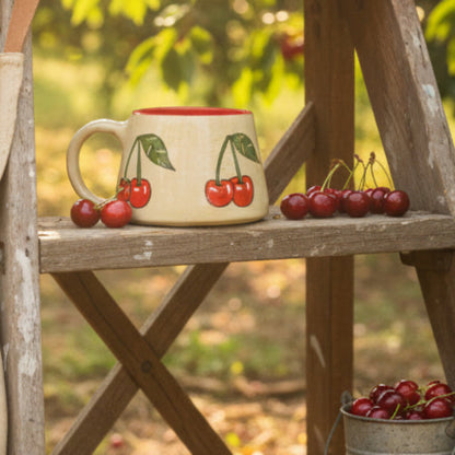 Ceramic mug with cherry design on a wooden surface
