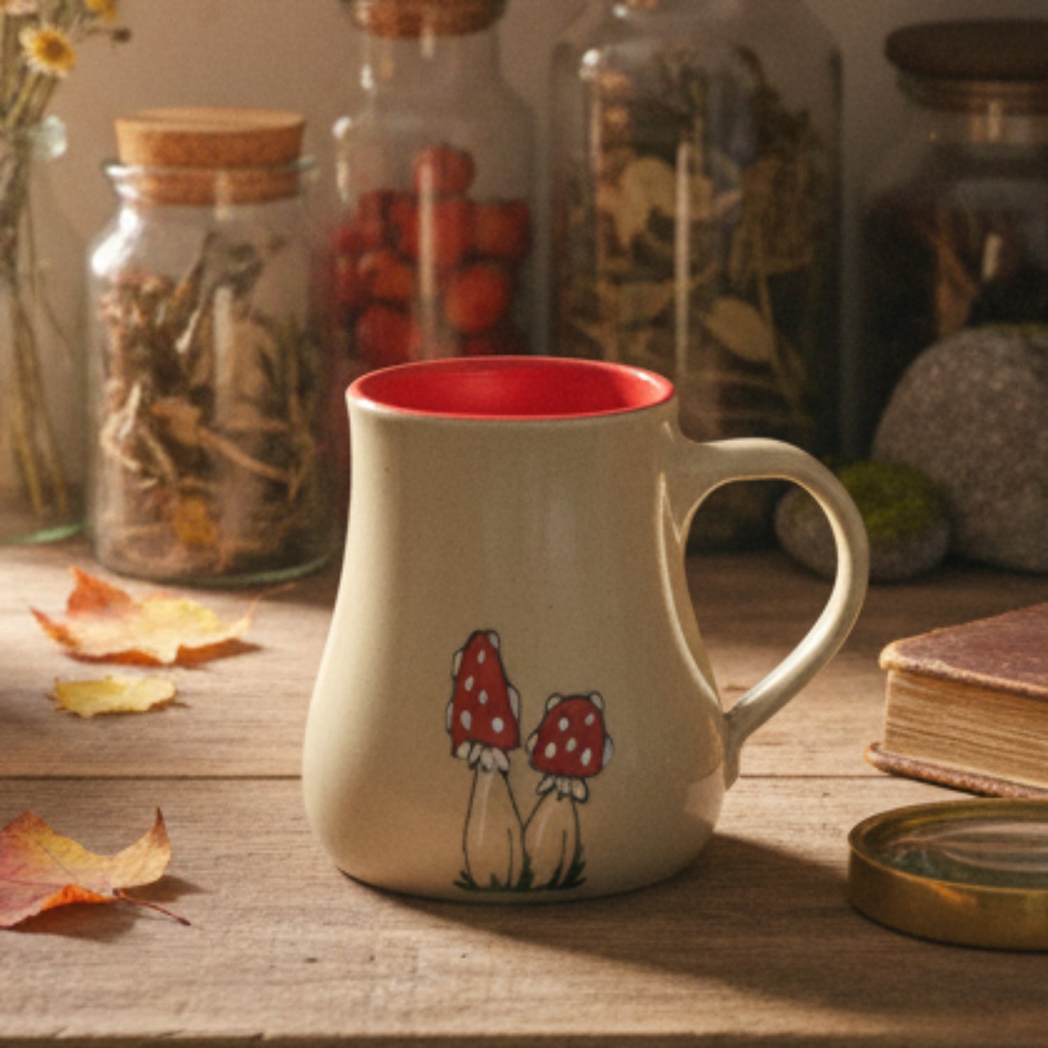 Ceramic mug with red interior and mushroom design on a wooden surface